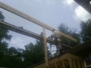Carpenter setting a ridge beam over a new addition frame — Ice Dam Removal by Roofing Brothers in North Babylon