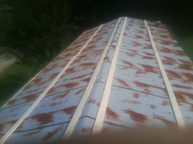 Rusted metal roof panels with new wood purlins before replacement — Storm Damage Roof Repair in North Babylon by Roofing Brothers