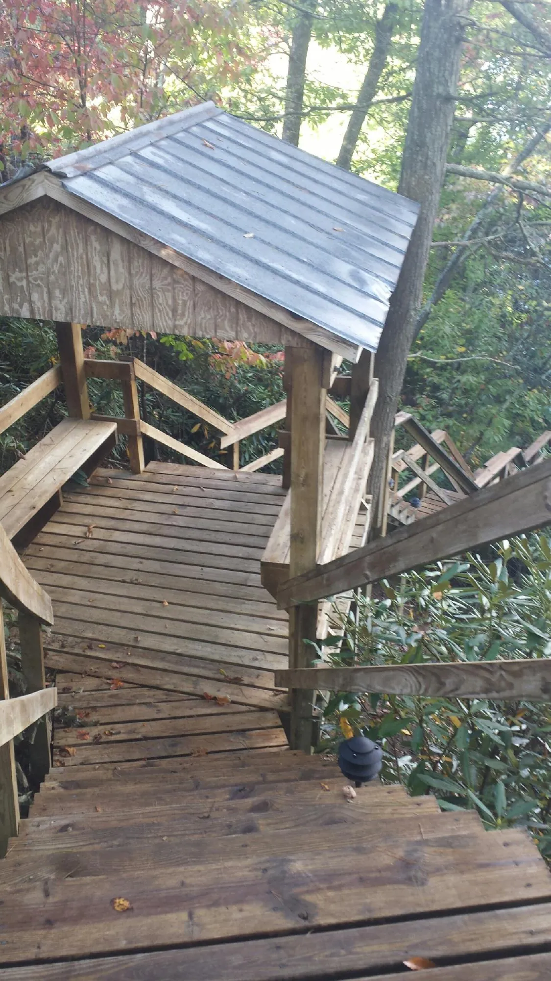 Metal roofed shelter over wooden steps on a wooded walkway — Skylight Repair & Installation work by our crew in North Babylon