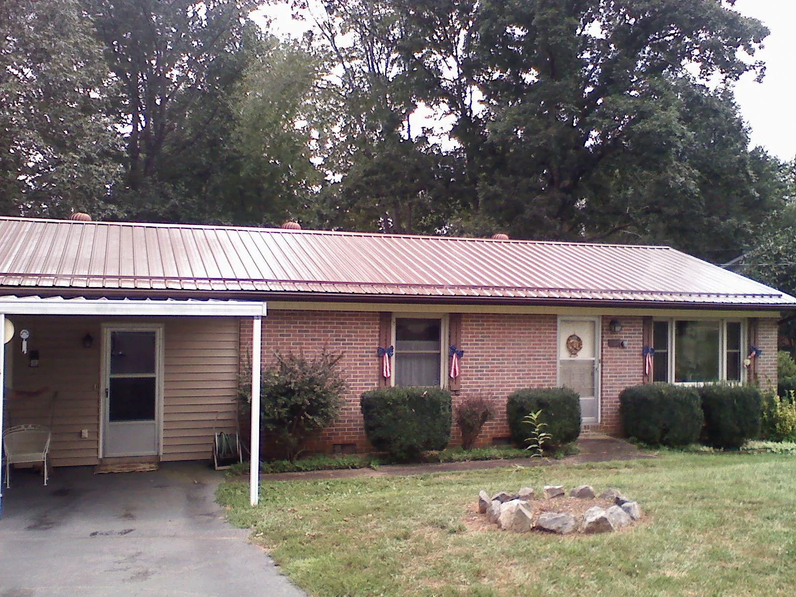 Bronze metal roof and carport on a brick ranch home — Roof Repair work by our crew in North Babylon